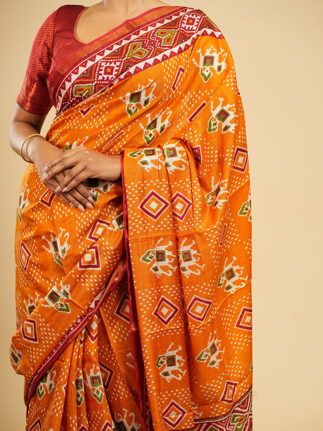 Orange Modal Patola saree draped full-length, showing the geometric double-ikat pattern — Koshnika